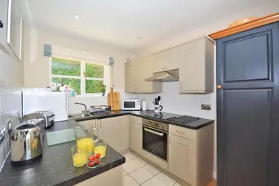 a kitchen with white cabinets and a black counter top at 2 Bed in Little Petherick oc-p00635 in Little Petherick