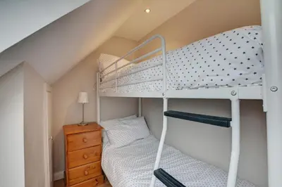 a bedroom with two bunk beds and a dresser at 2 Bed in Little Petherick oc-p00635 in Little Petherick