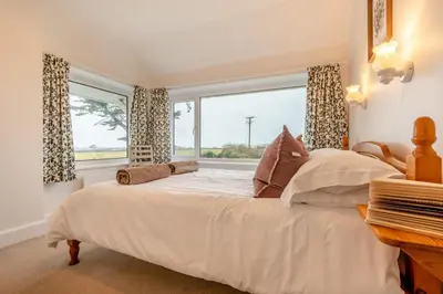 a bedroom with a large bed and a window at 1 Bed in St. Merryn oc-p00645 in St Merryn