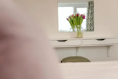 a vase of flowers sitting on a shelf with a mirror at 1 Bed in St. Merryn oc-p00645 in St Merryn