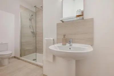 a white bathroom with a sink and a shower at 1 Bed in St. Merryn oc-p00645 in St Merryn