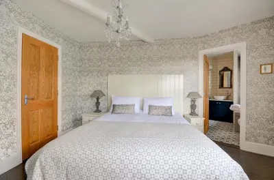 a bedroom with a large white bed and a bathroom at 3 Bed in Fowey oc-p00647 in Fowey