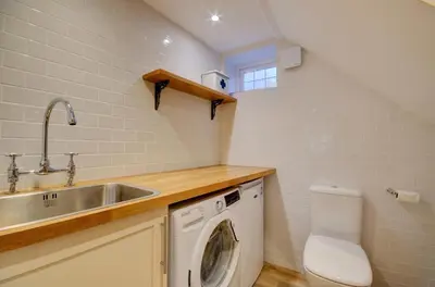 a small kitchen with a sink and a washing machine at 3 Bed in Fowey oc-p00647 in Fowey