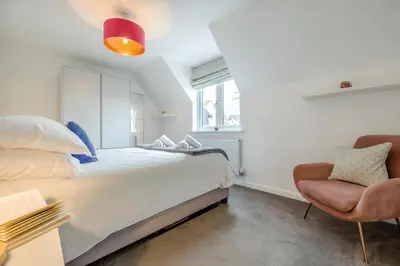 a bedroom with a large bed and a chair at 2 Bed in Padstow oc-p00655 in Padstow