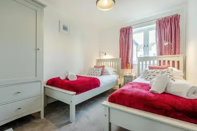 a bedroom with two beds and a window with pink curtains at 2 Bed in Padstow oc-p00655 in Padstow
