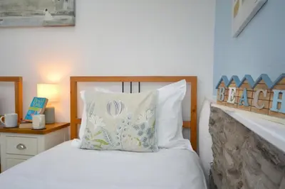 a bedroom with a white bed with a wooden headboard at 2 Bed in Padstow oc-p00670 in Padstow