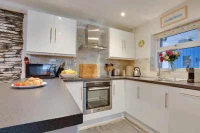 a kitchen with white cabinets and a plate of fruit on the counter at 2 Bed in Padstow oc-p00670 in Padstow