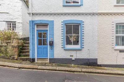 a blue door on a white house with stairs at 2 Bed in Fowey oc-p00671 in Fowey
