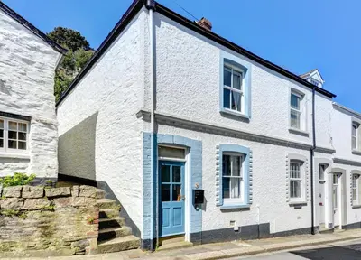a white house with a blue door on a street at 2 Bed in Fowey oc-p00671 in Fowey