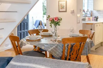 a dining room table with a vase of flowers on it at 2 Bed in Fowey oc-p00671 in Fowey