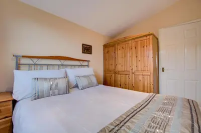 a bedroom with a bed and a wooden cabinet at 2 Bed in St. Merryn oc-p00673 in St Merryn