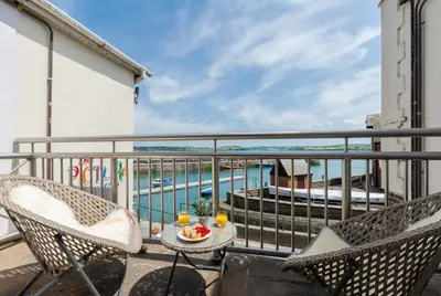 a balcony with two chairs and a table with food on it at 1 Bed in Padstow oc-p00685 in Padstow