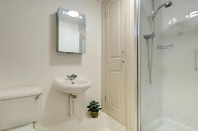 a white bathroom with a sink and a shower at 1 Bed in Padstow oc-p00685 in Padstow
