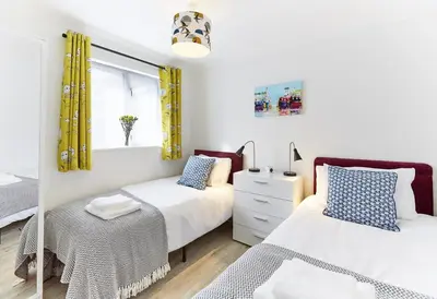 a bedroom with two beds and a window with yellow curtains at 2 Bed in St. Ives oc-p00693 in Carbis Bay