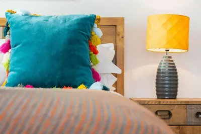 a blue pillow sitting on a bed next to a lamp at 3 Bed in Perranporth oc-p00695 in Perranporth