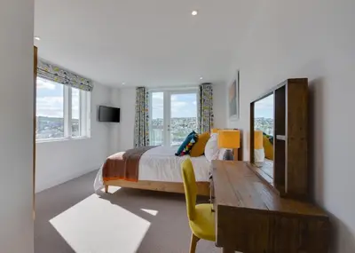 a bedroom with a bed and a desk and a mirror at 3 Bed in Perranporth oc-p00695 in Perranporth