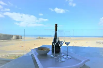 a table with a bottle of wine and two glasses at 3 Bed in Perranporth oc-p00695 in Perranporth