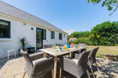 a wooden table and chairs on a patio at 4 Bed in Trevone oc-p00696 in Padstow