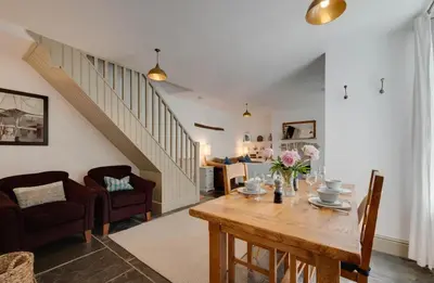a living room with a table and a staircase at 2 Bed in Polruan oc-p00697 in Fowey
