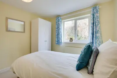 a bedroom with a bed with blue curtains and a window at 5 Bed in Mevagissey oc-p00699 in Mevagissey