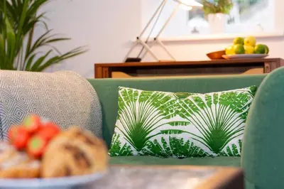 a green couch with a pillow and a plate of fruit at 2 Bed in Fowey oc-p00703 in Fowey