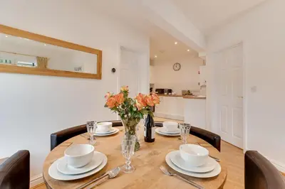 a dining room table with a vase of flowers on it at 2 Bed in Fowey oc-p00708 in Fowey