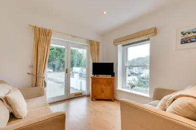 a living room with a couch and a tv and a window at 2 Bed in Fowey oc-p00708 in Fowey