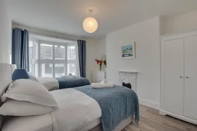 two beds in a bedroom with a fireplace at 4 Bed in Padstow oc-p00718 in Padstow