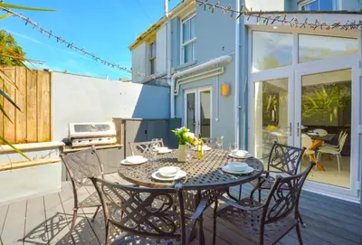 a patio with a table and chairs on a balcony at 4 Bed in Padstow oc-p00718 in Padstow