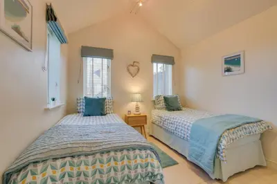 two beds in a room with two windows at 3 Bed in Trevone oc-p00723 in Padstow