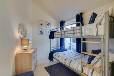a bunk bed room with two bunk beds and a desk at 3 Bed in Trevone oc-p00723 in Padstow