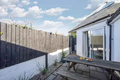 a patio with a wooden bench next to a fence at 3 Bed in Trevone oc-p00723 in Padstow