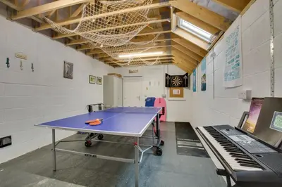 a ping pong table in a gymnasium with a ping pong table at 3 Bed in St. Merryn oc-p00725 in St Merryn