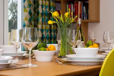 a wooden table with glasses and plates and a bottle of wine at 3 Bed in St. Merryn oc-p00725 in St Merryn