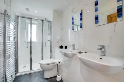 a white bathroom with a toilet and a sink at 3 Bed in St. Merryn oc-p00725 in St Merryn