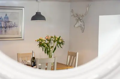 a dining room with a table and chairs and a mirror at 1 Bed in Padstow oc-p00735 in Padstow