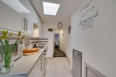 a kitchen with white counters and a clock on the wall at 1 Bed in Padstow oc-p00735 in Padstow