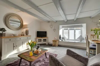 a living room with a table and a tv at 1 Bed in Padstow oc-p00735 in Padstow