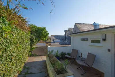 a patio with two chairs and a house at 1 Bed in Padstow oc-p00735 in Padstow