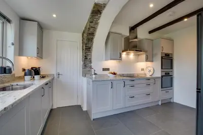 a kitchen with white cabinets and a sink at 5 Bed in Little Petherick oc-p00736 in Little Petherick