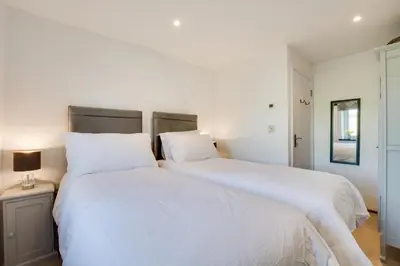 two beds in a bedroom with white sheets at 5 Bed in Little Petherick oc-p00736 in Little Petherick