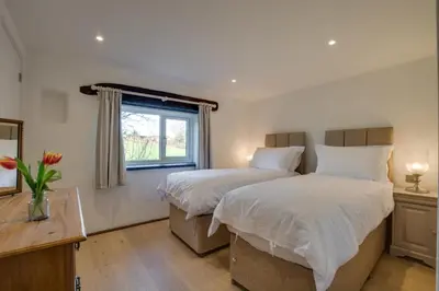 a bedroom with two beds and a window at 5 Bed in Little Petherick oc-p00736 in Little Petherick
