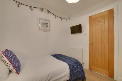 a bedroom with a bed and a television on the wall at 3 Bed in Padstow oc-p00742 in Padstow