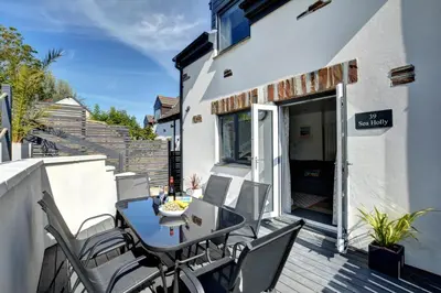 a patio with a table and chairs on a balcony at 3 Bed in Padstow oc-p00742 in Padstow