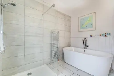 a white bathroom with a tub and a shower at 3 Bed in Trevone oc-p00758 in St Merryn