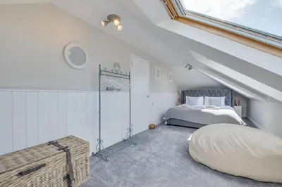 a attic bedroom with a bed and a window at 3 Bed in Trevone oc-p00758 in St Merryn