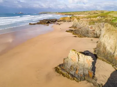 a sandy beach with rocks and the ocean at 3 Bed in Trevone oc-p00758 in St Merryn