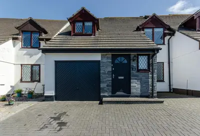 a house with a garage with a blue door at 4 Bed in Padstow oc-p00759 in Padstow