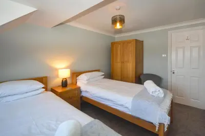 a bedroom with two beds and a lamp on a table at 4 Bed in Padstow oc-p00759 in Padstow