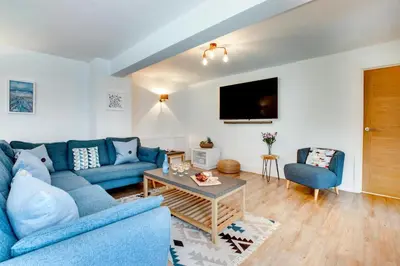 a living room with a blue couch and a table at 3 Bed in Padstow oc-p00793 in Padstow